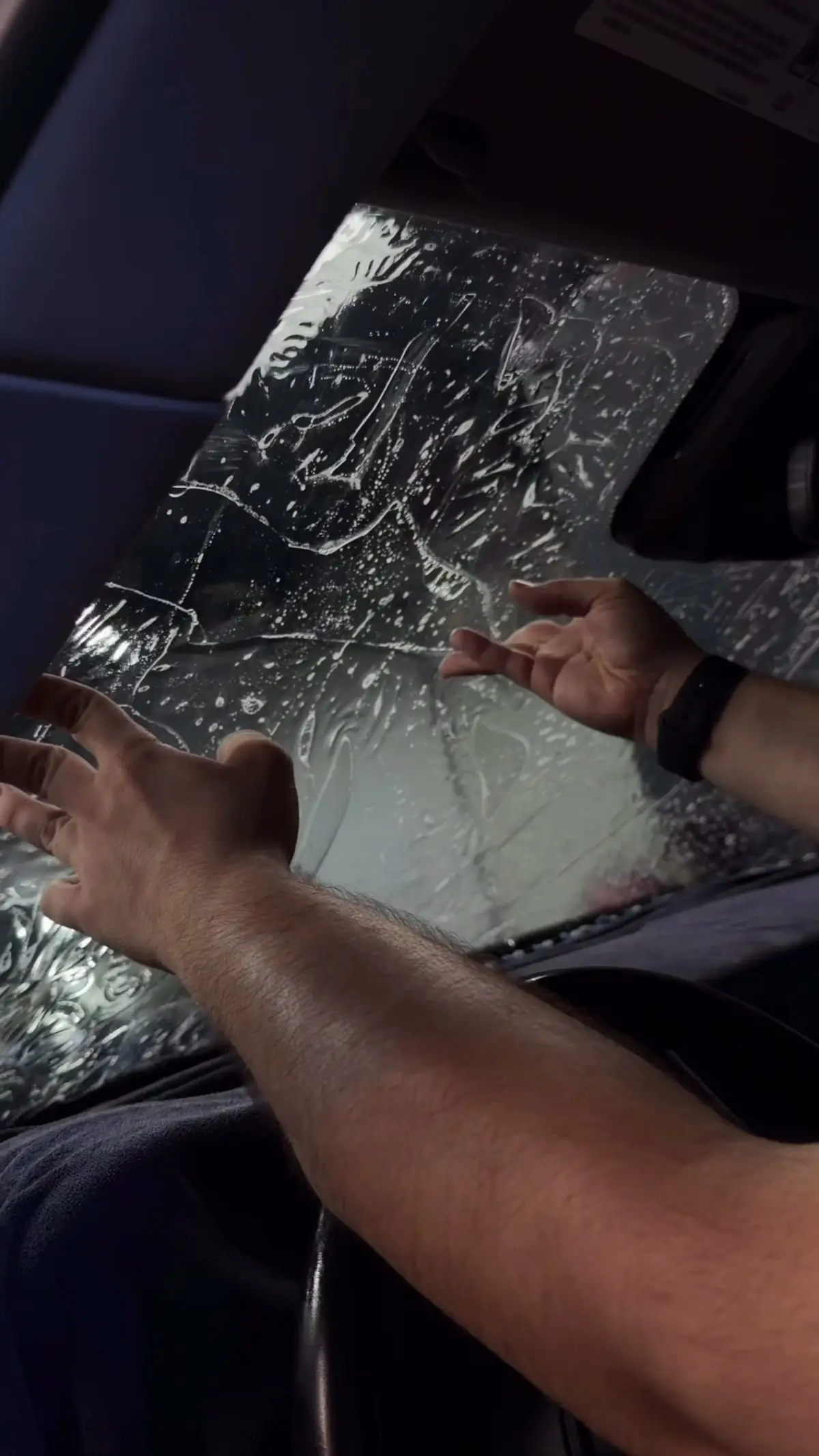 Installer applying ceramic tint film to a car window